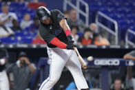 Miami Marlins' Jesus Aguilar hits a home run scoring Miguel Rojas, during the fourth inning of the first game of a baseball doubleheader against the Atlanta Braves, Saturday, Aug. 13, 2022, in Miami. (AP Photo/Wilfredo Lee)