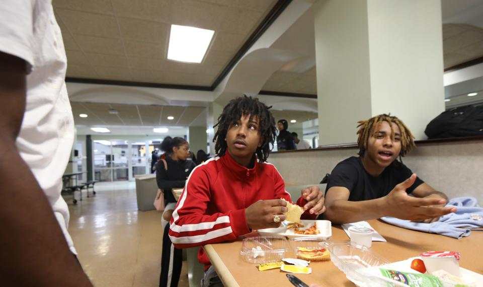 Wilson Magnet High School juniors Jahmere Libbett, right, and Ke'Sean Chung sit together and talk with friends over their lunch of pizza during their lunch period in the school cafeteria in Rochester Wednesday, June 8, 2022.