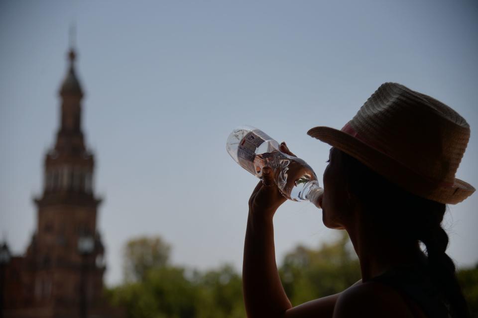 Una mujer bebe agua para combatir el calor en Sevilla.  Foto: CRISTINA QUICLER/AFP/Getty Images)