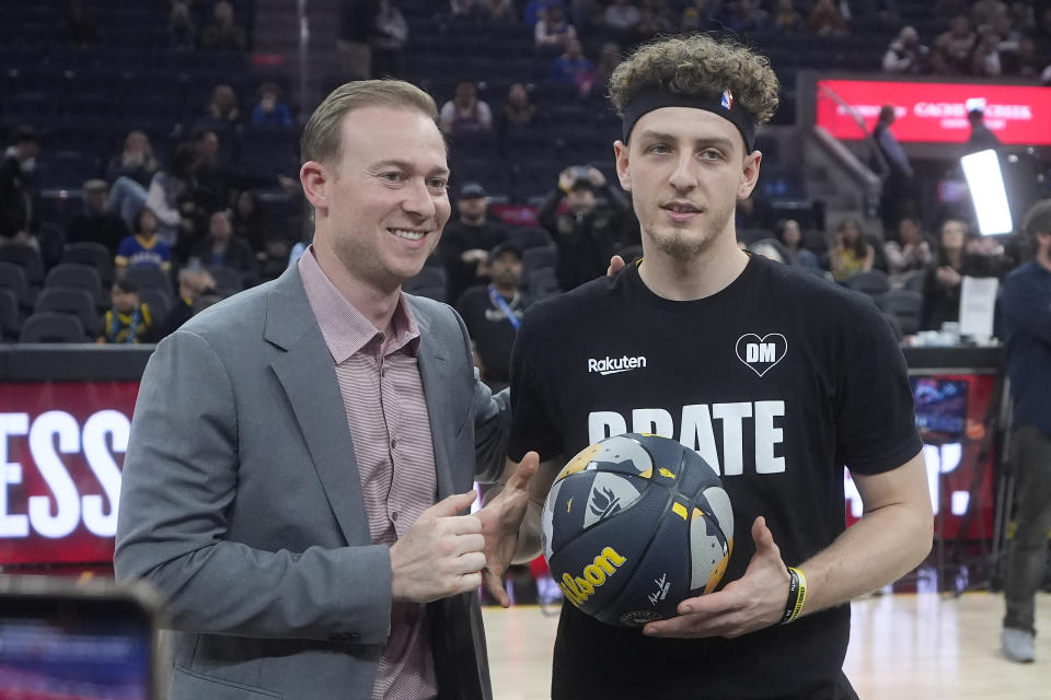 Golden State Warriors executive vice president Kirk Lacob, left, presents guard Brandin Podziemski with a 2024 NBA All-Star Rising Stars ball before an NBA basketball game between the Warriors and the Los Angeles Clippers in San Francisco, Wednesday, Feb. 14, 2024. (AP Photo/Jeff Chiu)