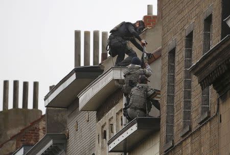 Belgian special forces police climb high on an apartment block during a raid, in search of suspected muslim fundamentalists linked to the deadly attacks in Paris, in the Brussels suburb of Molenbeek, November 16. 2015. REUTERS/Yves Herman