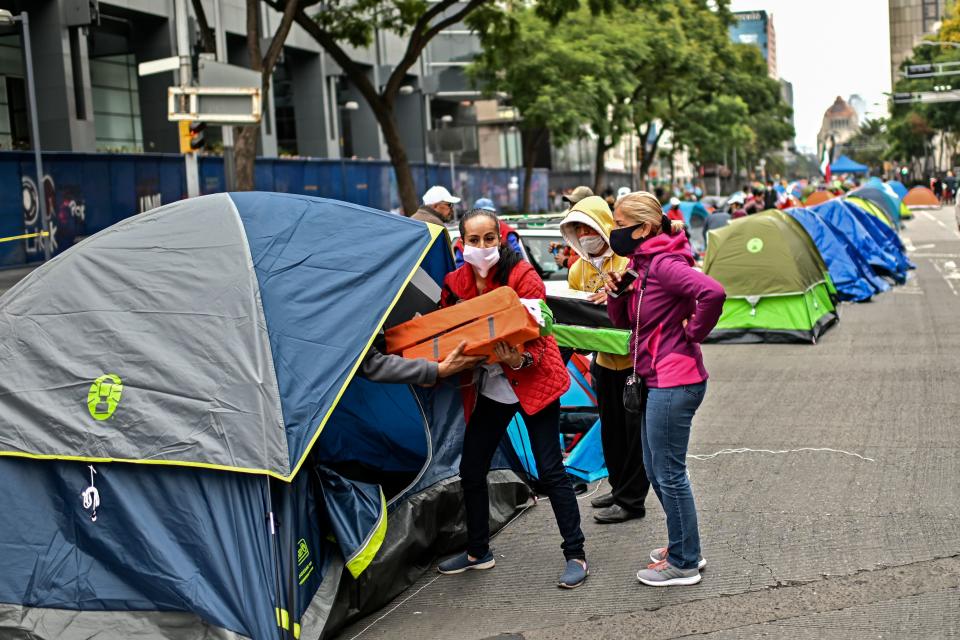 Members of the National Front Anti-AMLO (Frena), who will make a second attempt to reach Zocalo Square to protest against Mexican President Andres Manuel Lopez Obrador (ALMO), distribute tents as they camp on Juarez street in Mexico City on September 20, 2020, a day after being prevented by the local police to get to the city's main square, amid the COVID-19 novel coronavirus pandemic. (Photo by PEDRO PARDO / AFP) (Photo by PEDRO PARDO/AFP via Getty Images)