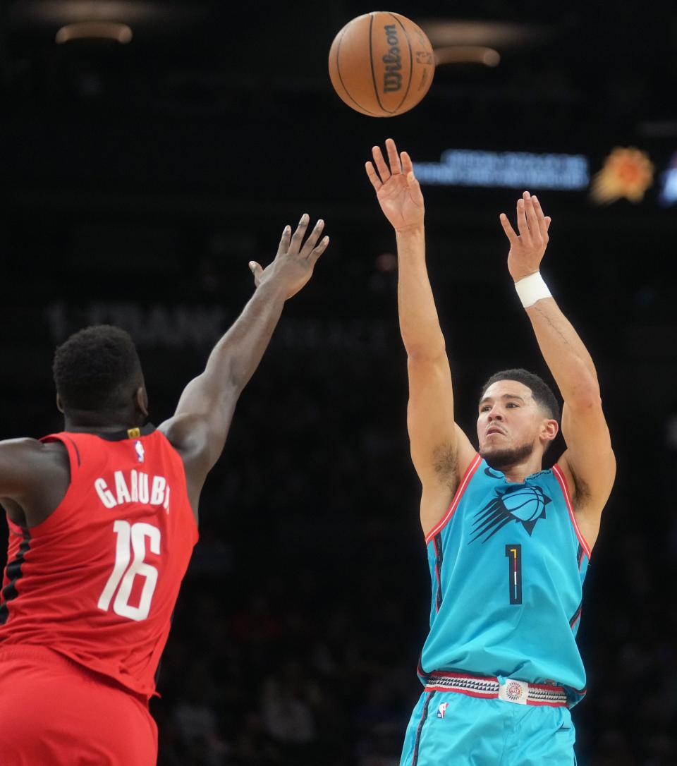 Dec 2, 2022; Phoenix, AZ, USA; Phoenix Suns guard Devin Booker (1) shoots the ball over Houston Rockets forward 	Usman Garuba (16) at Footprint Center. Mandatory Credit: Joe Rondone-Arizona Republic