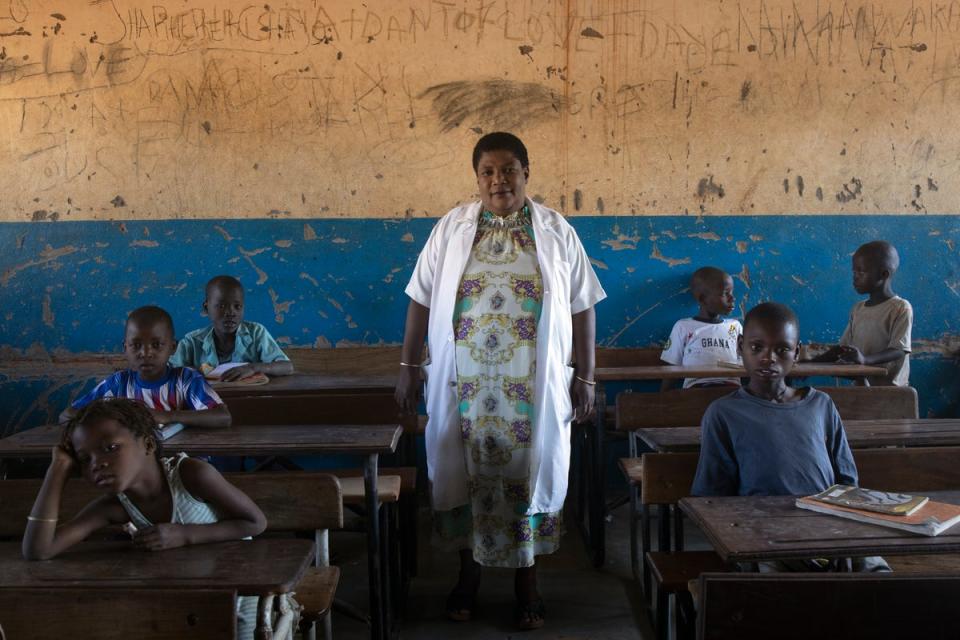 Lucia Tomocene poses with pupils in her classroom at Maratane refugee settlement school in Nampula province (Hélène Caux/UNHCR)