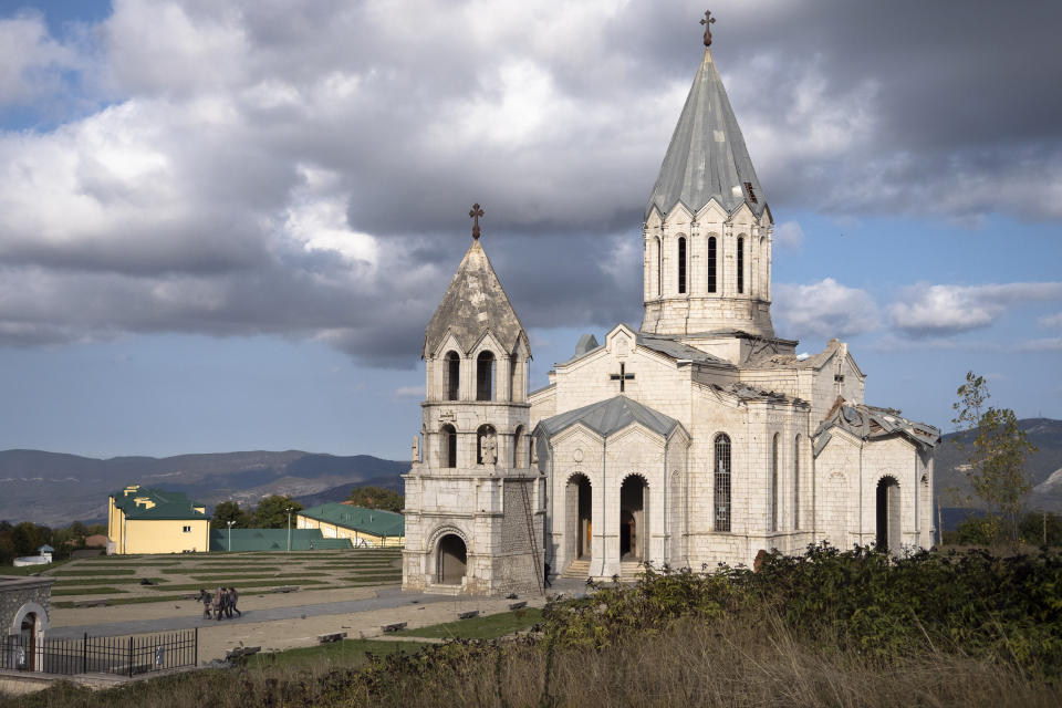 Men carry out furniture from the Holy Savior Cathedral damaged by shelling during a military conflict, in Shushi, outside Stepanakert, self-proclaimed Republic of Nagorno-Karabakh, Thursday, Oct. 8, 2020. Armenia accused Azerbaijan of firing missiles into the capital of the separatist territory of Nagorno-Karabakh, while Azerbaijan said several of its towns and its second-largest city were attacked. (AP Photo)