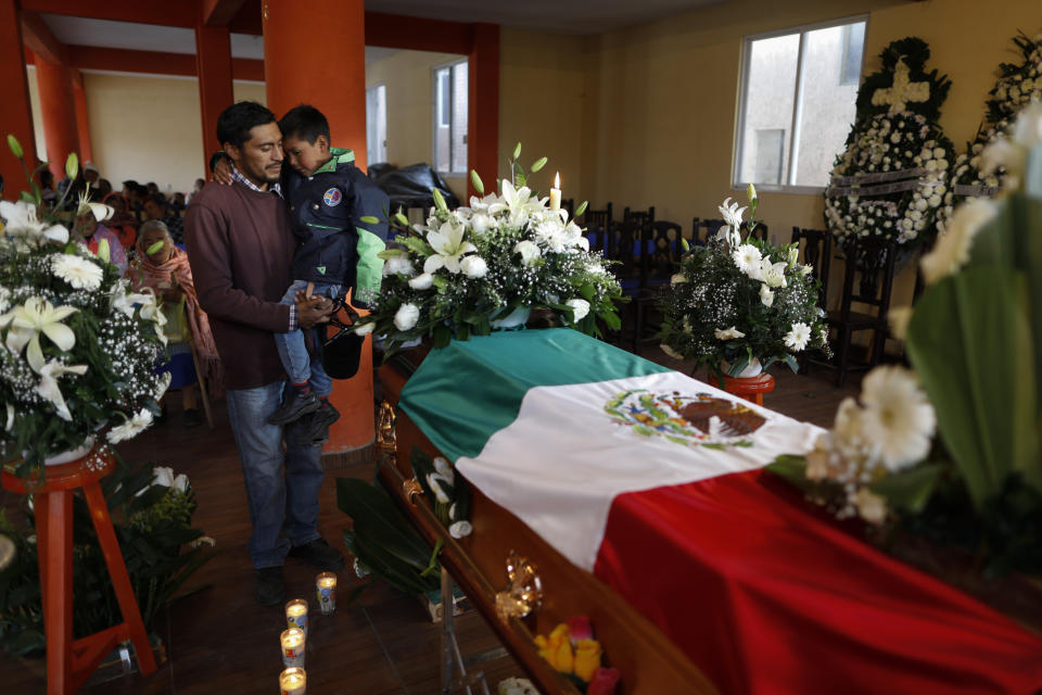 Mourners pay their respects next to the coffin of environmental activist Homero Gomez Gonzalez at his wake in Ocampo, Michoacan state, Mexico, Thursday, Jan. 30, 2020. Relatives of the anti-logging activist who fought to protect the winter habitat of monarch butterflies don't know whether he was murdered or died accidentally, but they say they do know one thing for sure: something bad is happening to rights and environmental activists in Mexico, and people are afraid.(AP Photo/Rebecca Blackwell)