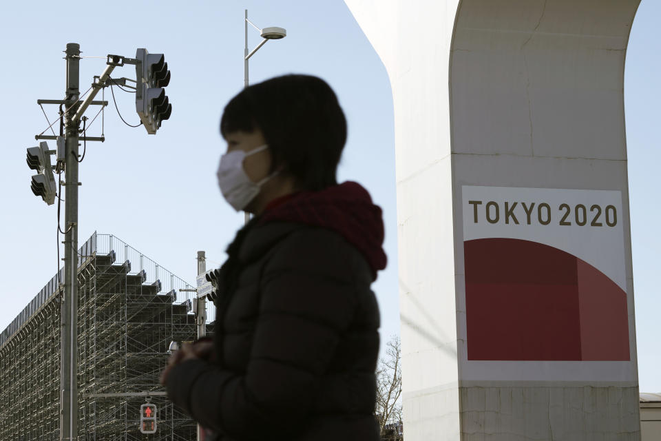 A woman wearing a protective mask to help curb the spread of the coronavirus walks near one of the Olympic venues in Tokyo Wednesday, Jan. 20, 2021. The Japanese capital confirmed more than 1,200 new coronavirus cases on Wednesday. (AP Photo/Eugene Hoshiko)