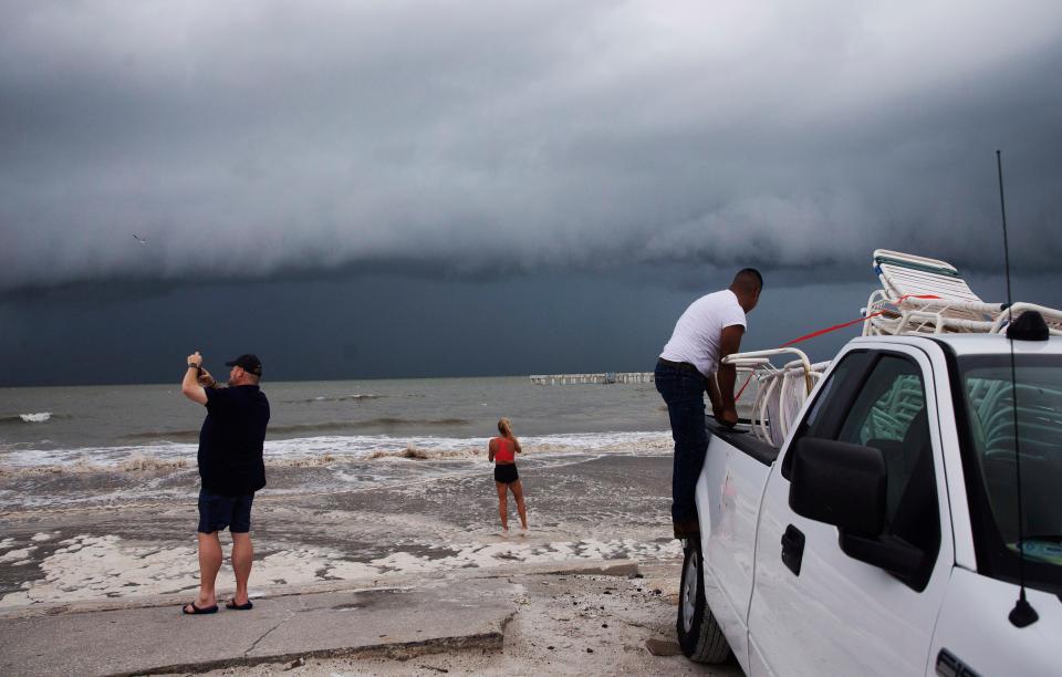 Beachgoers check out the surf as Hurricane Idalia approaches Florida at Times Square on Fort Myers Beach on Tuesday, Aug. 29, 2023.