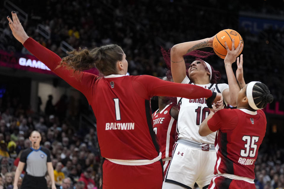 South Carolina center Kamilla Cardoso (10) shoots over North Carolina State center River Baldwin (1) and guard Zoe Brooks (35) during the first half of a Final Four college basketball game in the women's NCAA Tournament, Friday, April 5, 2024, in Cleveland. (AP Photo/Morry Gash)