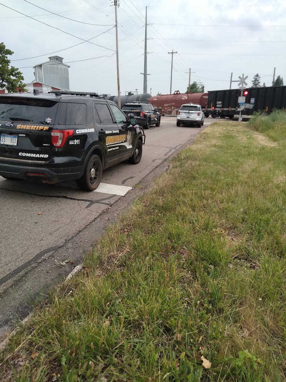 Police vehicles were staged at the Millett Highway train crossing in Delta Township on Friday evening.