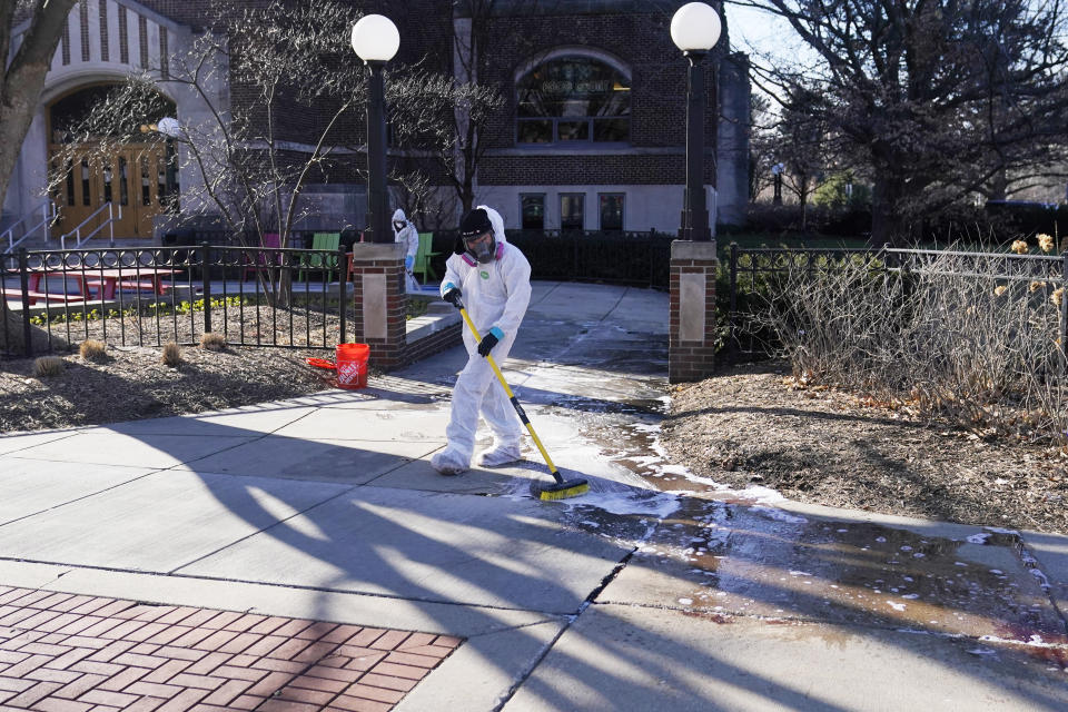 Workers clean up outside Berkey Hall at Michigan State University, Tuesday, Feb. 14, 2023, in East Lansing, Mich. Police say the gunman who killed himself hours after fatally shooting three students at Michigan State University was 43-year-old Anthony McRae. Police also say five people who are in critical condition Tuesday are also students. (AP Photo/Carlos Osorio)