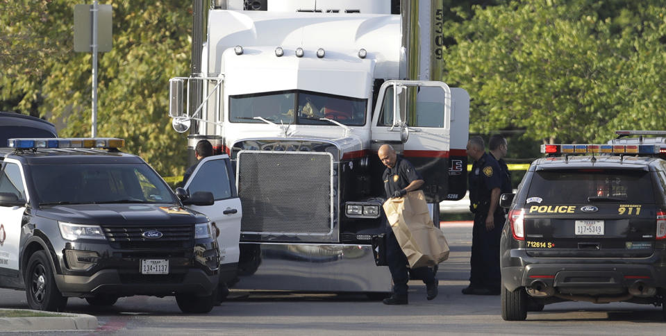 <p>San Antonio police officers investigate the scene where eight people were found dead in a tractor-trailer loaded with at least 30 others outside a Walmart store in stifling summer heat in what police are calling a horrific human trafficking case, Sunday, July 23, 2017, in San Antonio. (AP Photo/Eric Gay) </p>