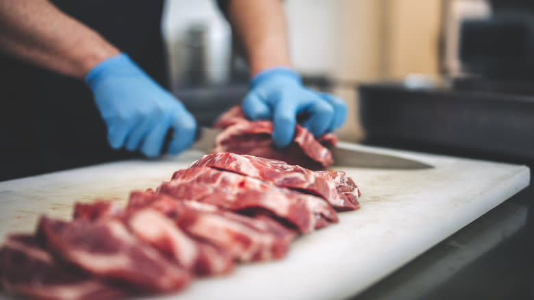 butcher cutting up raw meat