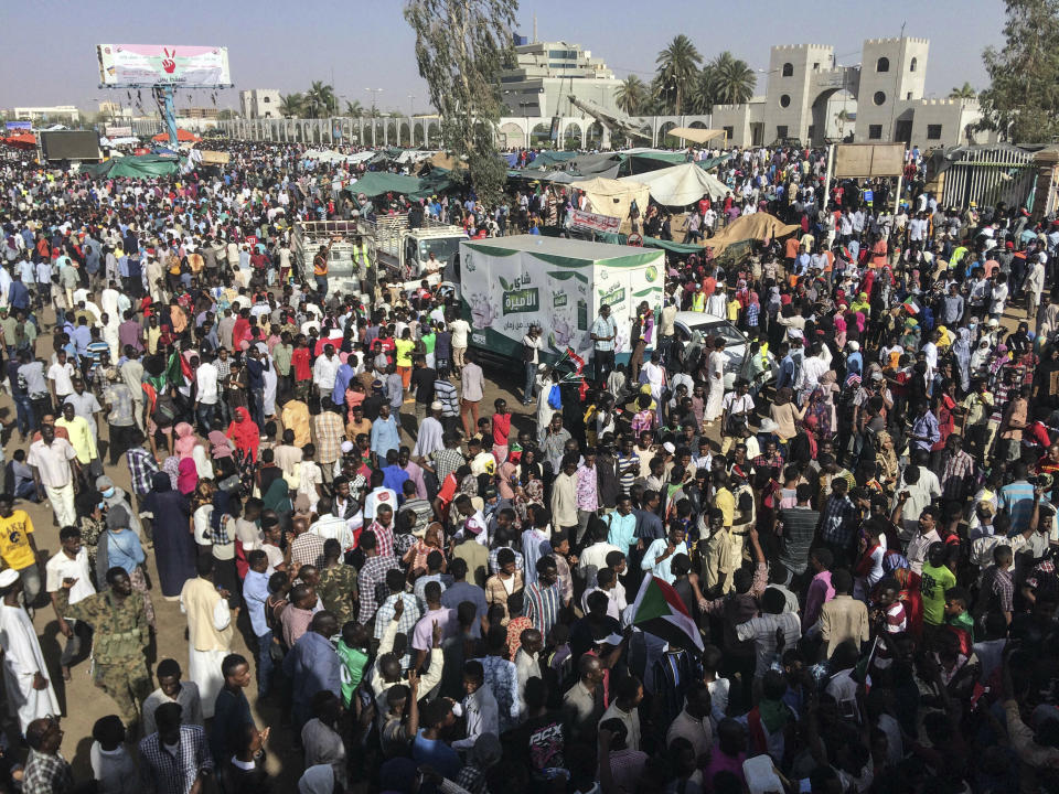 Sudanese demonstrators march with national flags as they gather during a rally demanding a civilian body to lead the transition to democracy, outside the army headquarters in the Sudanese capital Khartoum on Saturday, April 13, 2019. The military overthrew President Omar al-Bashir on Thursday after almost four months of protests calling for an end to his nearly 30-year rule. (AP Photo)