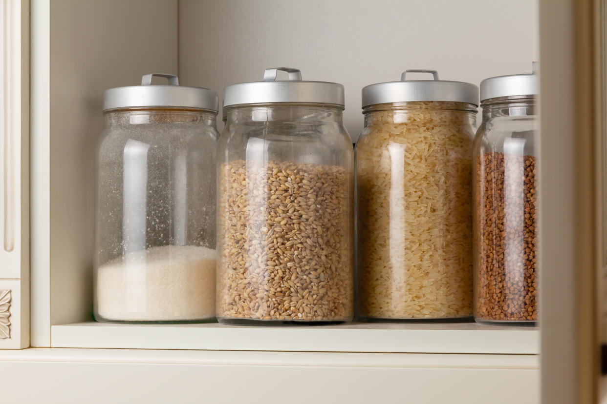  Glass jars containing dry food on a shelf. 