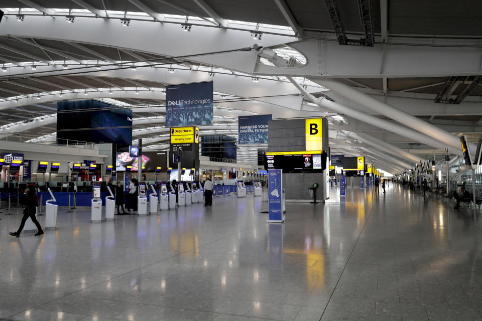 Terminal 5 at Heathrow Airport in London, which handles British Airways flights, stands virtually empty of passengers as staff are seen during a British Airways pilots' strike, Monday, Sept. 9, 2019. British Airways says it has had to cancel almost all flights as a result of a pilots' 48-hour strike over pay. (AP Photo/Matt Dunham)