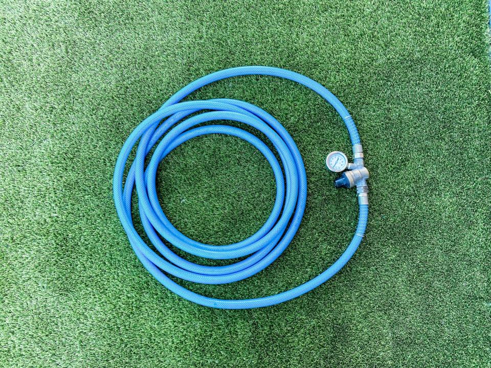 A blue waterhose on the grass