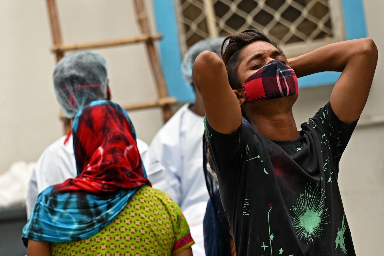 <p>Relatives and family members mourn after they received the body of a patient who died of Covid-19 in Delhi</p> (AFP via Getty Images)