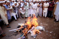 Supporters of Islami Oikya Jote, an Islamist political party, burn an effigy representing French President Emmanuel Macron during a protest against the publishing of caricatures of the Prophet Muhammad they deem blasphemous, in Dhaka, Bangladesh, Wednesday, Oct. 28, 2020. Muslims in the Middle East and beyond on Monday called for boycotts of French products and for protests over the caricatures, but Macron has vowed his country will not back down from its secular ideals and defense of free speech. Posters read "France is the enemy of humanity. World citizens fight back." second left, "Muslims of the world stand against insults to the prophet," third right and "Stop buying products from France. In the name of the Prophet," left. (AP Photo/Mahmud Hossain Opu)