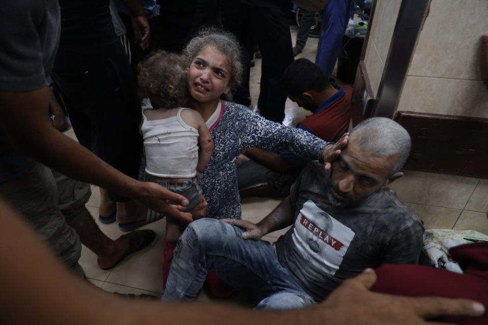 An injured girl hugs her brother and checks on her wounded father at al-Aqsa Martyrs hospital after an Israeli bombardment of a residential building in the Bureij refugee camp, June 4, 2024.