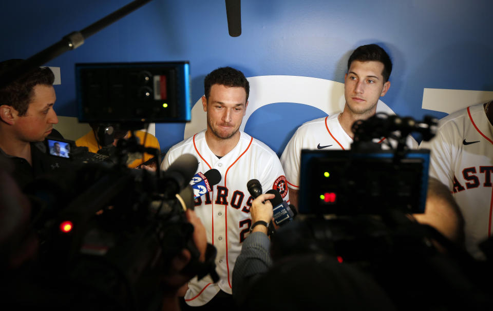 Houston Astros' Alex Bregman, center, is interviewed by the media during the baseball team's FanFest, Saturday, Jan. 18, 2020, in Houston. Astros' Kyle Tucker, right, looks on. (Steve Gonzales/Houston Chronicle via AP)