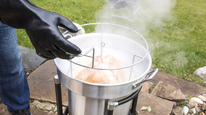 Person deep-frying turkey outside