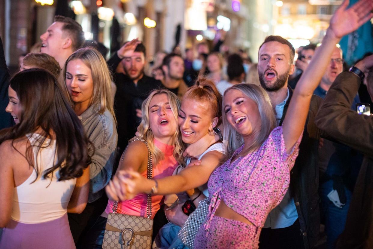 People sing and dance as they watch a street performer in Leicester Square: PA