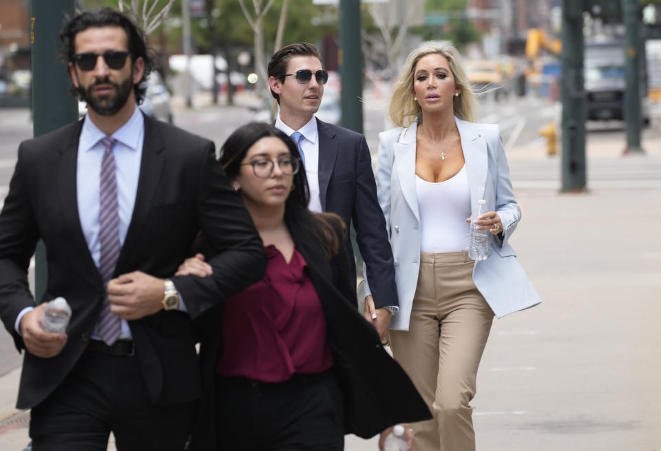 FILE - The son, left, and daughter, back right, of Pittsburgh dentist Lawrence "Larry" Rudolph head into federal court for the afternoon session of the trial, July 13, 2022, in Denver. Rudolph, a wealthy dentist convicted of killing his wife during an African safari so he could be with his girlfriend, is expected to be sentenced to life in prison Monday, Aug. 21, 2023, for a murder prosecutors say capped off a lifetime “spent seeking domination and control over others through wealth and power.” The couple's two adult children, Julian and AnaBianca Rudolph, have so far opted not to to speak publicly about the death. (AP Photo/David Zalubowski, File)