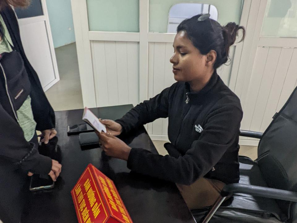 A woman pretending to check passports at the border crossing between Vietnam and Laos.