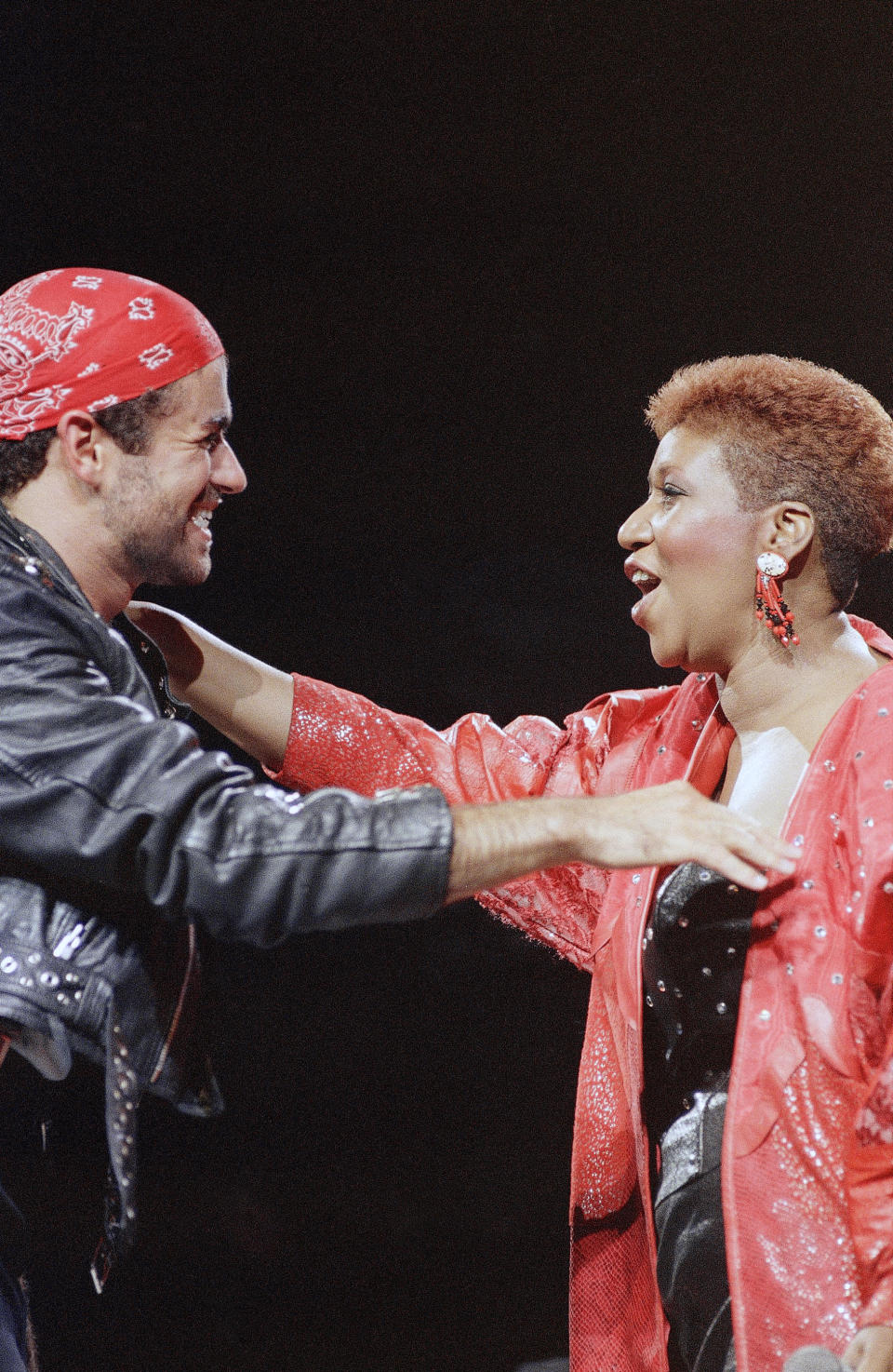 <p>Aretha Franklin, wearing a red leather studded jacket and short auburn haircut, joins George Michael on stage during his Faith World Tour in Detroit. The duo sang their Grammy-winning hit “I Knew You Were Waiting.” (AP Photo/Rob Kozloff) </p>