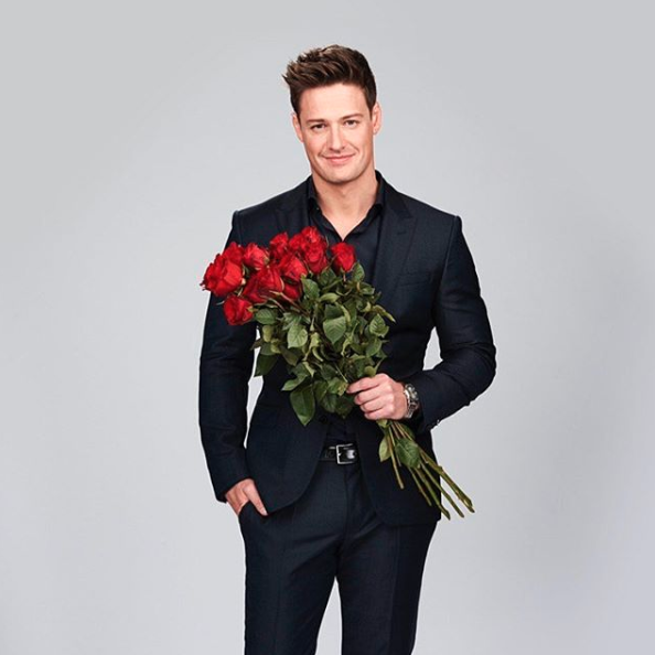The Bachelor Australia 2019 Matt Agnew holds a bouquet of roses dressed in a suit