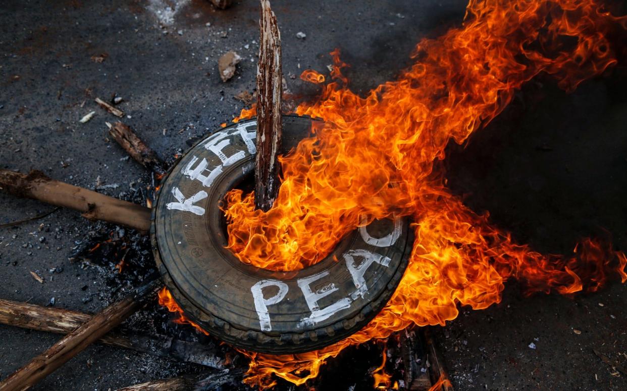 Supporters of the opposition leader Raila Odinga burn a tire with a message reading 'Keep Peace', chanting 'No Raila (Odinga), No Peace', in Kibera slum, one of Odinga's strongholds in Nairobi, Kenya, 10 August 2017 - EPA