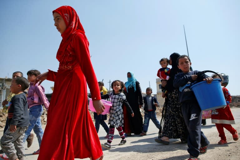 Iraqis flee on foot carrying their belongings to escape the fighting for Mosul's Old City with the Islamic State group on March 30, 2017