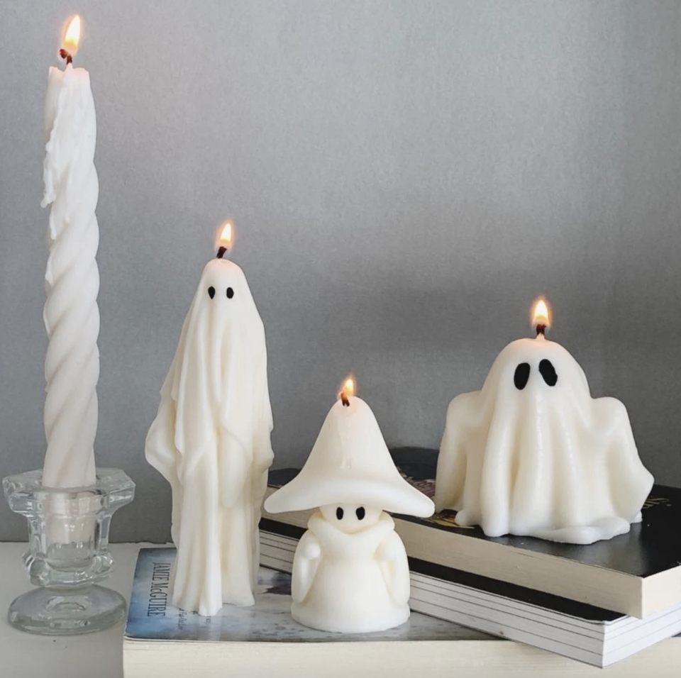 Ghost Candles in white on books (Photo via Etsy)