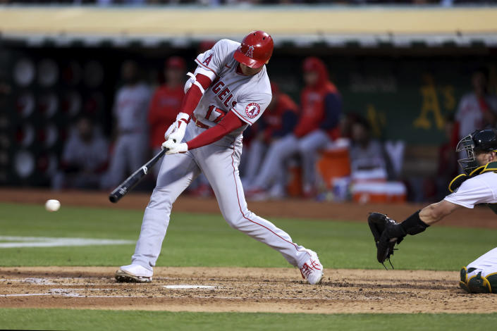 Los Angeles Angels' Shohei Ohtani hits a single next to Oakland Athletics catcher Sean Murphy during the fifth inning of a baseball game in Oakland, Calif., Tuesday, Aug. 9, 2022. (AP Photo/Jed Jacobsohn)
