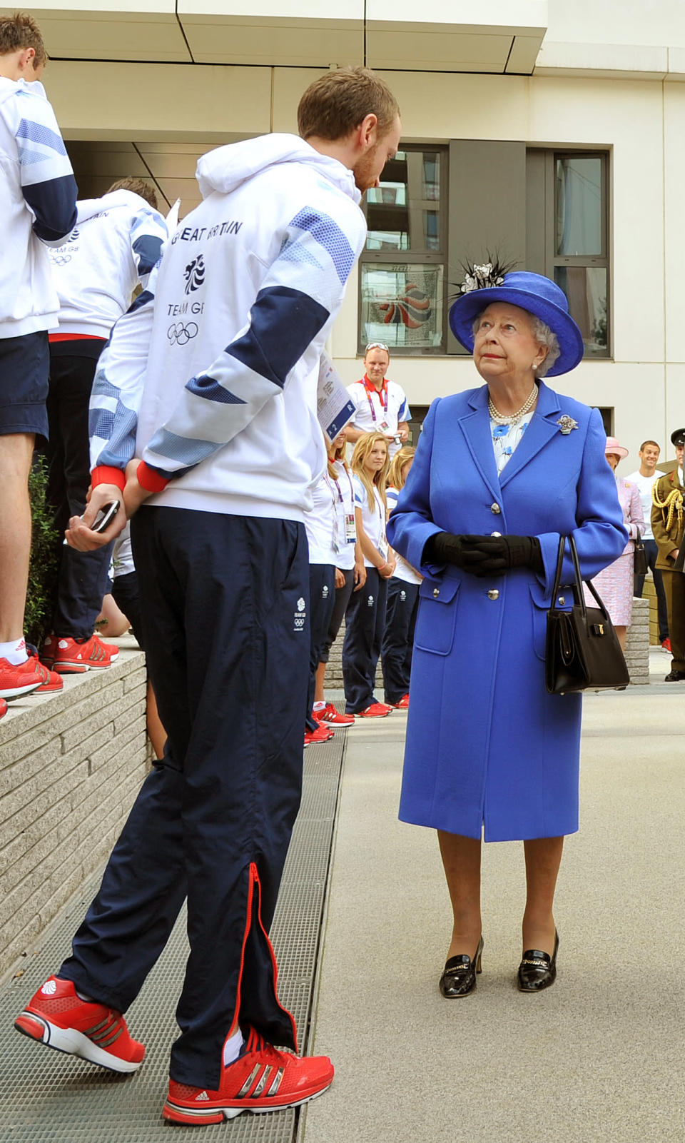 LONDON, UNITED KINGDOM - JULY 28: Queen Elizabeth Il meets one of the taller members of the Great Britain team during a tour of the Athletes Village on day one of the London 2012 Olympics Games on July 28, 2012 in London, England. (Photo by John Stillwell/WPA Pool/Getty Images)