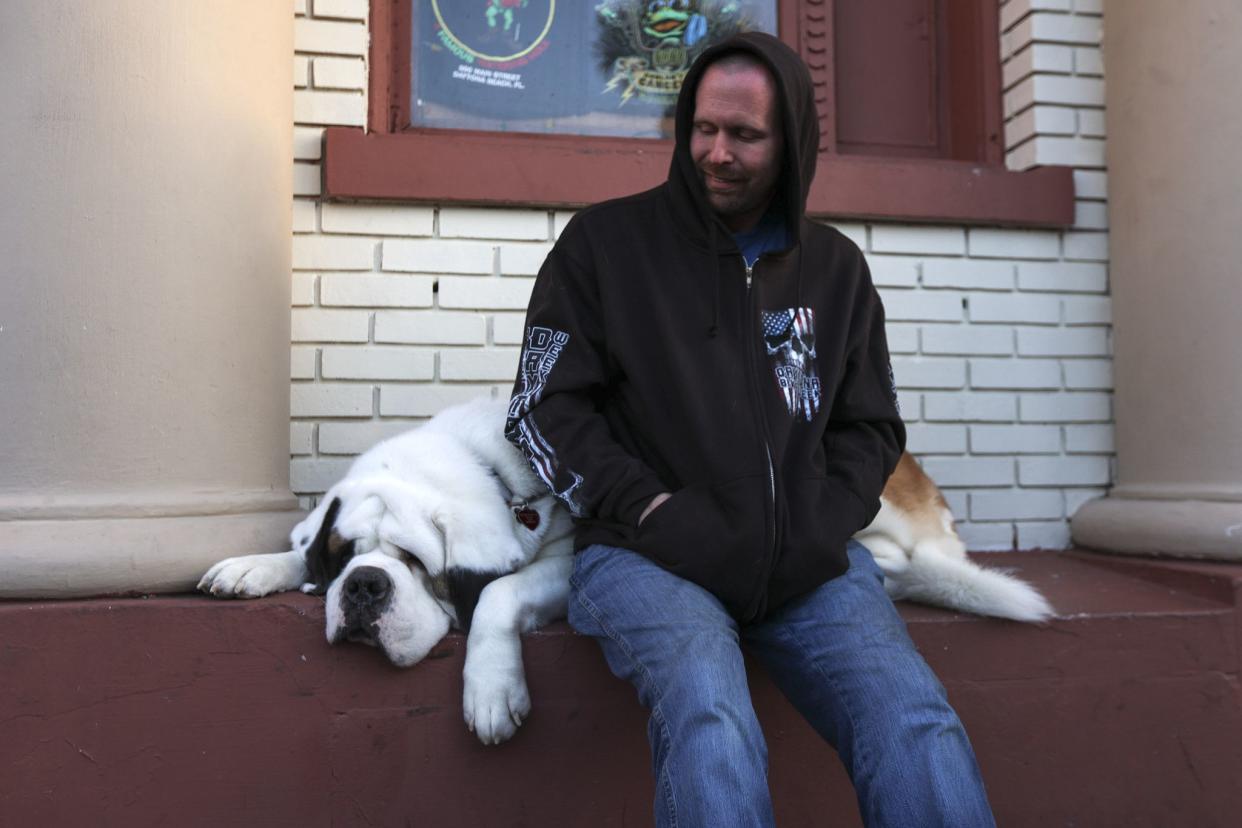 Jeff Foster sits with his dog, Buddy, along Main Street in Daytona, FL during Bike Week on Friday, March 5, 2021. (Sam Thomas/Orlando Sentinel)