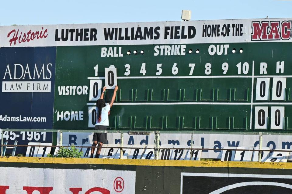 Luther Williams Field scoreboard operator Christian Kendrick changes the visitor score on the manual scoreboard during the Macon Bacon game against Catawba Valley Stars on Tuesday, June 25, 2024, in Macon, Georgia. Luther Williams Field saw extensive renovations in 2018, but the scoreboard remains the original from the park’s opening in 1929.