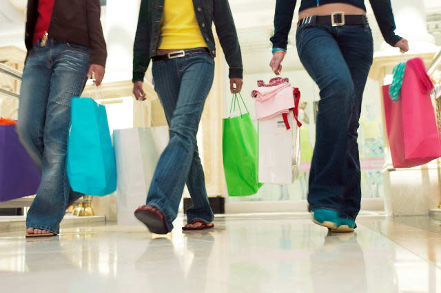 B8GTTP Three teens carrying shopping bags at the mall