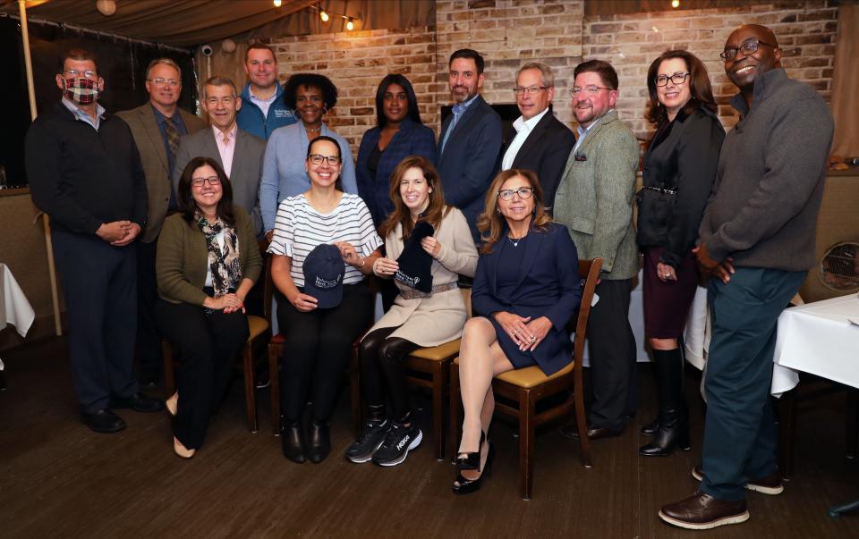 Jeanette Gisbert, seated second from left, executive director of Volunteer New York!, is pictured with participants in the Volunteer New York! 2022 Volunteer Hat campaign at Sam's of Gedney Way in White Plains on Oct. 19, 2022.