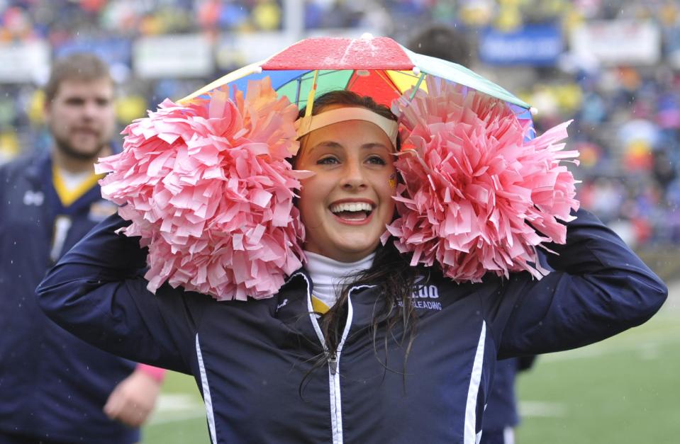 Toledo cheerleader Alysa Malcolm puts on an umbrella hat during the second quarter of an NCAA college football game between Toledo and Navy in Toledo, Ohio, Saturday, Oct. 19, 2013. (AP Photo/David Richard)