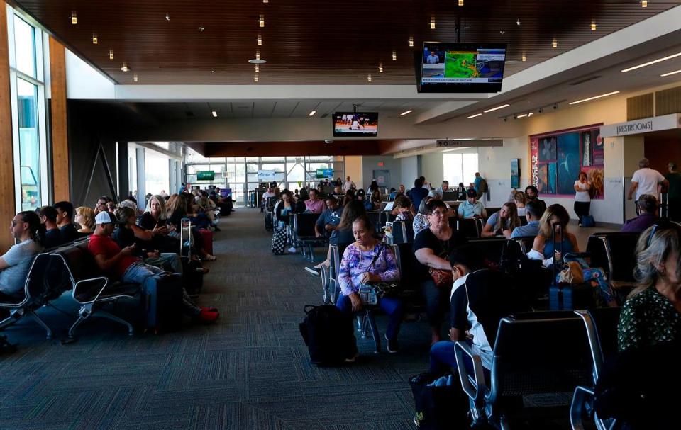 Passengers sit in the terminal waiting to board their departing planes at the Tri-Cities Airport in Pasco.