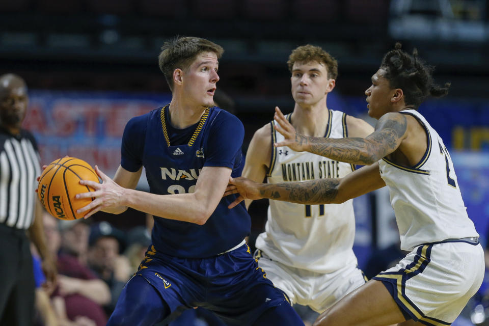 Northern Arizona forward Nik Mains (20) looks to pass the ball as Montana State defense close in on him in the first half of an NCAA college basketball game for the championship of the Big Sky men's tournament in Boise, Idaho, Wednesday, March 8, 2023.. (AP Photo/Steve Conner)