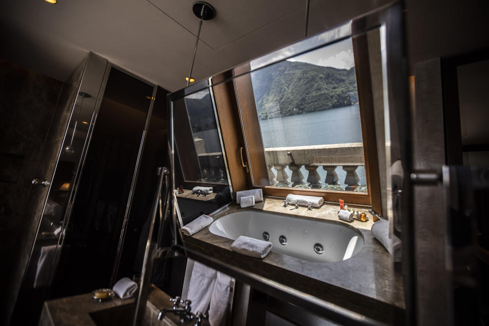This picture taken on Thursday, May 14, 2020, shows a bathtub overlooking the lake, reflected on a bathroom mirror of the historical Grand Hotel Tremezzo, in Tremezzo, on Como Lake, Italy. The hotel was built in 1901. (AP Photo/Luca Bruno)