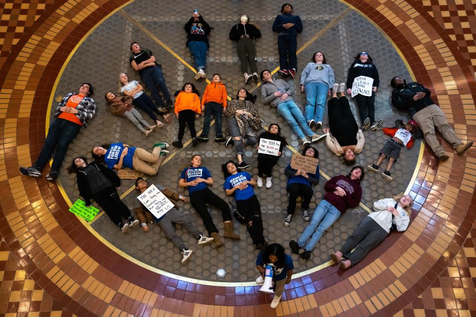 Students participate in a die-in during a rally against legislation that will allow Iowans to keep guns in locked cars in the parking lots of public buildings like schools, in the rotunda of the Iowa State Capitol, on Monday, April 24, 2023, in Des Moines. 