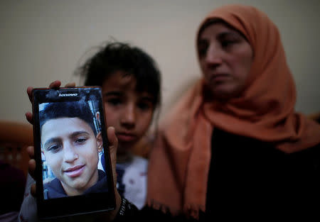 The mother of Mohammed Ayoub, 14, a Palestinian boy who was shot dead by Israeli troops during clashes at the Israel-Gaza border, shows her son's photo at her house in the northern Gaza Strip April 21, 2018. REUTERS/Mohammed Salem