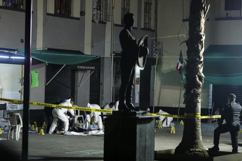 Investigators cover the bodies of victims of a shooting at Garibaldi Plaza in Mexico City, Friday, Sept. 14, 2018. Mexican authorities say four people were killed and nine wounded in a shooting at the capital's emblematic Garibaldi Plaza, a popular spot for tourists. (AP Photo)