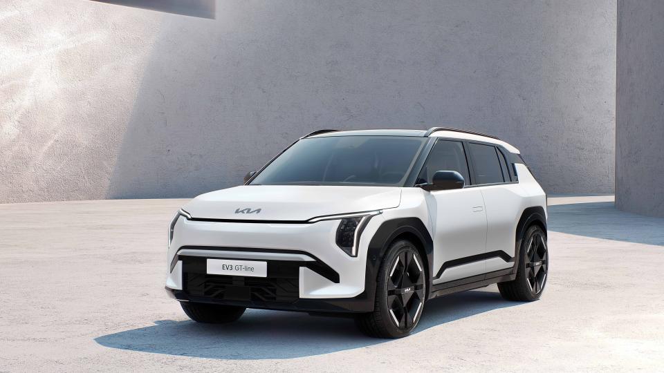 A Kia EV3 GT-Line compact electric SUV is parked in front of a building.