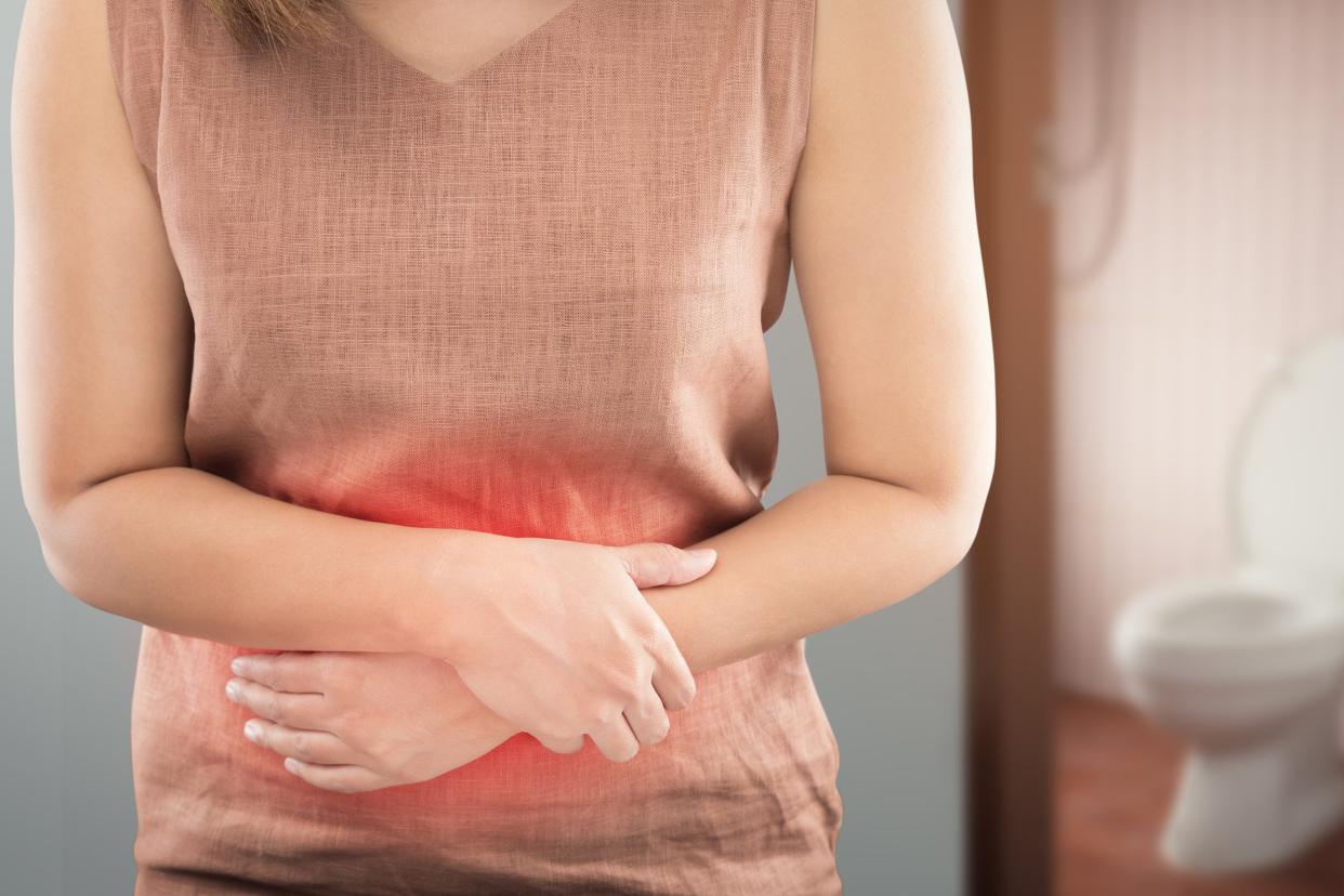 woman with bowel problems in front of bathroom