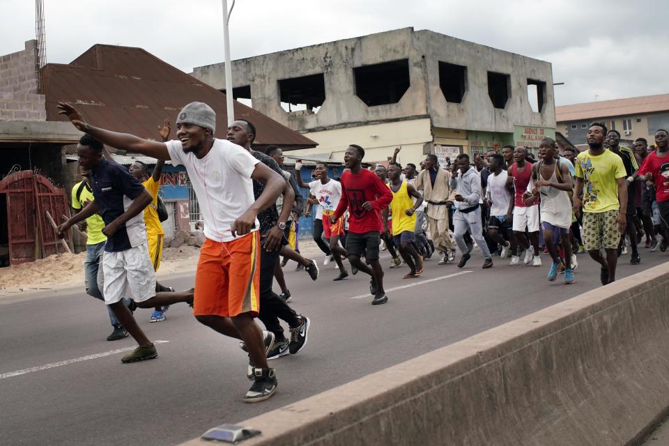 Congolese sportsmen run towards the main stadium in Kinshasa, Congo, Tuesday Jan. 8, 2019, to participate in a general boxing and martial arts competition. As Congo anxiously awaits the outcome of the presidential election, many in the capital say they are convinced that the opposition won and that the delay in announcing results is allowing manipulation in favor of the ruling party. (AP Photo/Jerome Delay)